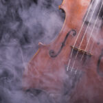 A viola or violin in smoke on a black background