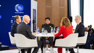 Piyush Goyal, India's Union Minister of Commerce and Industry, smiling at the circular panel table alongside international panellists at the Berlin Global Dialogue 2026