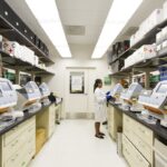 Scientist operating genomic sequencing machines in a biotech lab