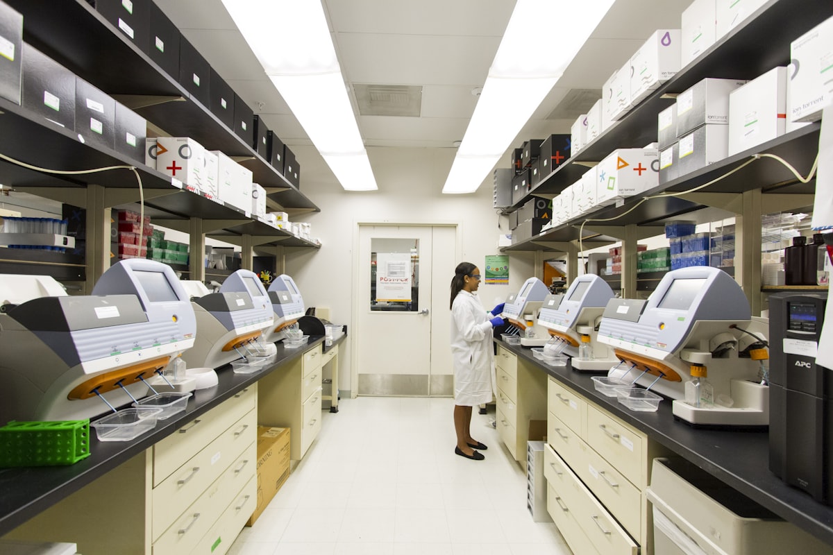 Scientist operating genomic sequencing machines in a biotech lab